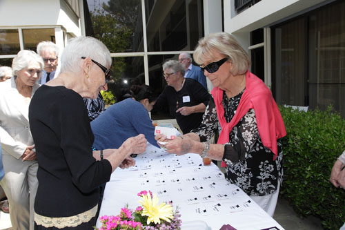 Lee Zenzipper gets her nametag from Diane Adler; Jan Ambler (background)